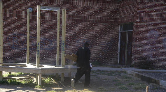 Playground thief making off with planks of wood - through ruptured fence